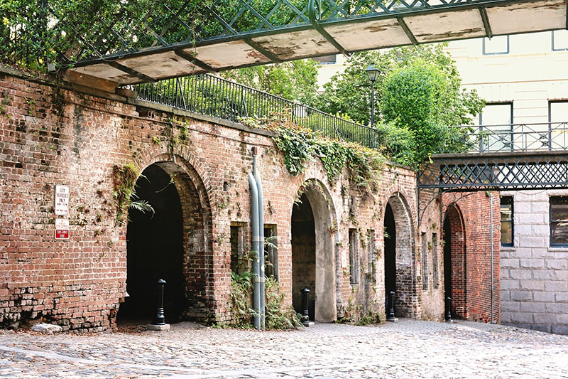 Cobblestone streets meet a brick wall with 4 tunnel-like openings at the Cluskey Vaults.