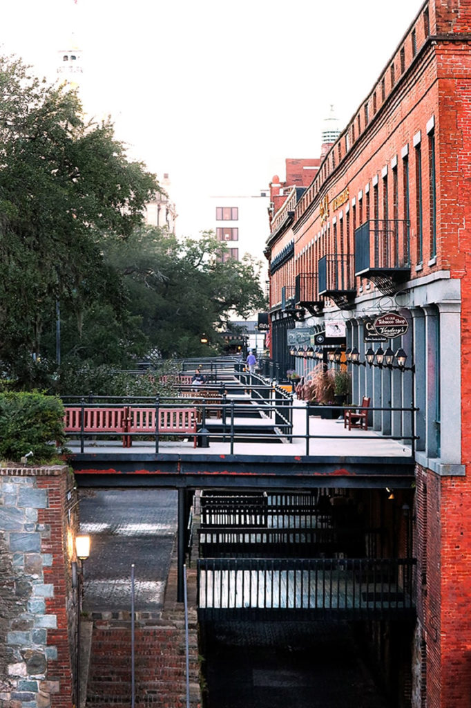 Factor's Walk consists of 5 or 6-story brick buildings with iron walkways connecting them to a nearby bluff and a steep drop to the cobblestone streets below.