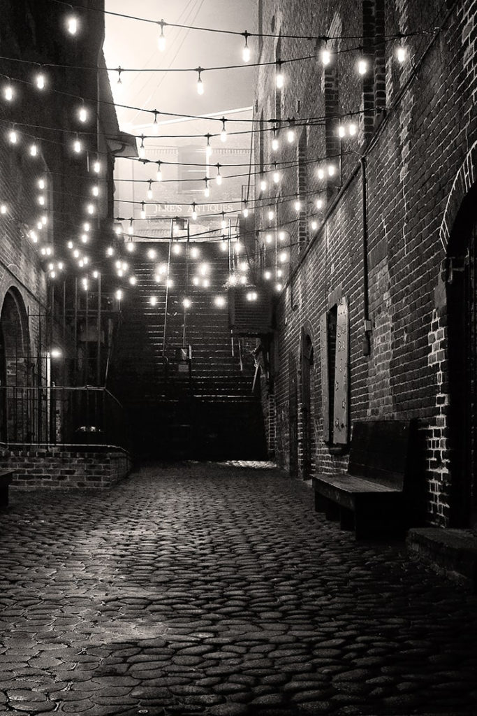 B&W dimly lit alleyway leading to the Stone Stairs of Death in Savannah GA.