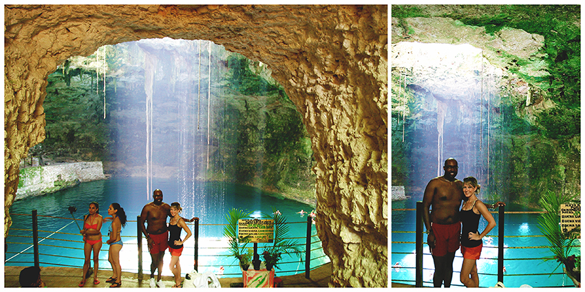 A man and a woman standing inside a cavernous opening with bright blue water behind them and sunlight streaming down from a hole in the roof of the cave.