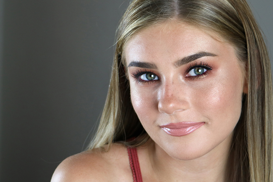 Image of girl looking directly into camera with rust-colored eyeshadow and smoky eyeliner.