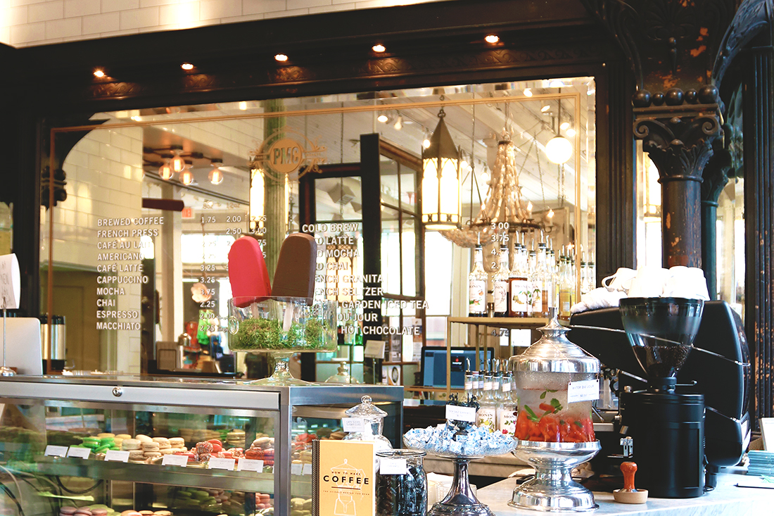 Parisian-style cafe with an antique mirror and treats displayed on the countertop and in beautiful display cases.