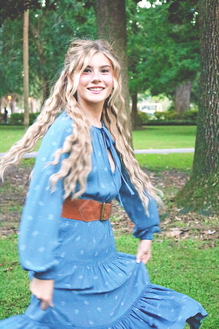 Mamma Mia Hair Tutorial: Image of a young girl smiling and twirling in a long, blue peasant dress