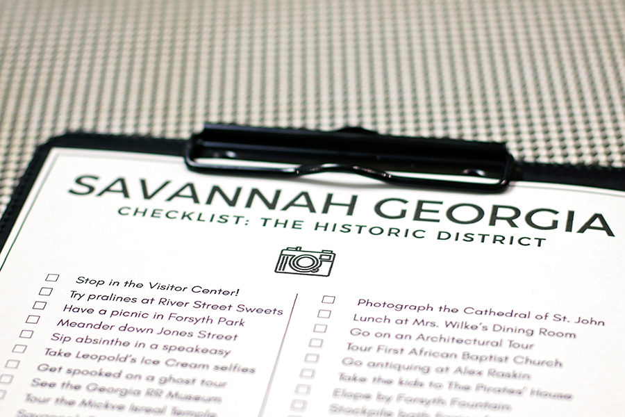 Black clipboard holding a printable checklist of a Savannah Historic District bucket list.