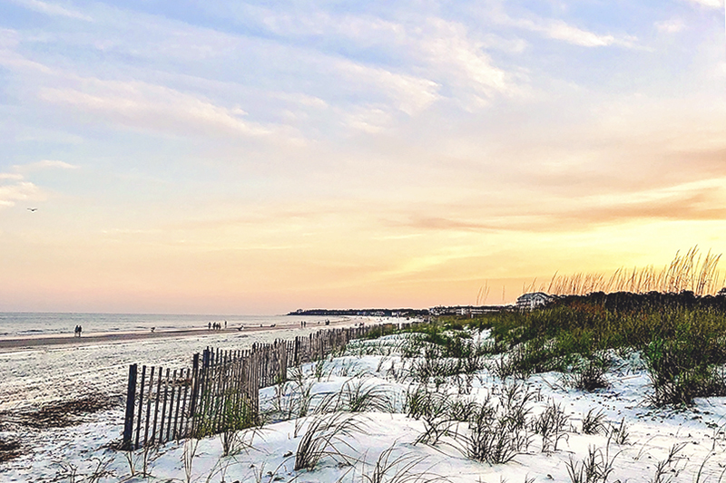 Yellow and orange sunset over the sand dunes at Hilton Head's Folly Field Beach.