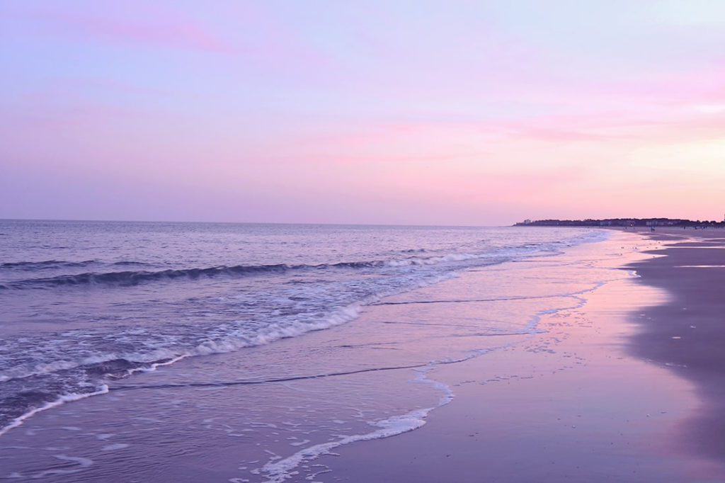 Hilton Head sunset beach scene with pinkish-purple tinted skies on Folly Beach.