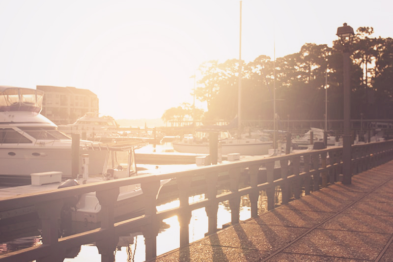 Golden rays of sunshine blanket the sailboats in Hilton Head's Shelter Cove Marina.