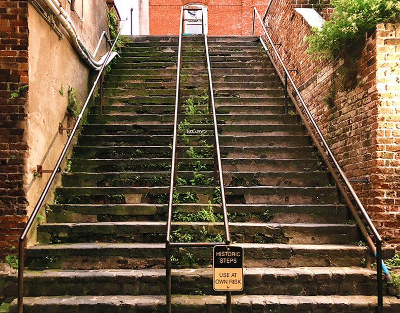 The Stone Stairs of Death in Savannah are steep and old, with crumbling bricks and moss-covered areas.