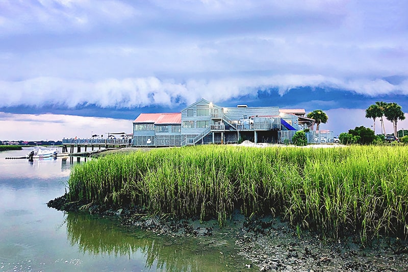 Wide shot of The Old Oyster Factory on Hilton Head Island as a massive wave-shaped storm cloud looms overhead.